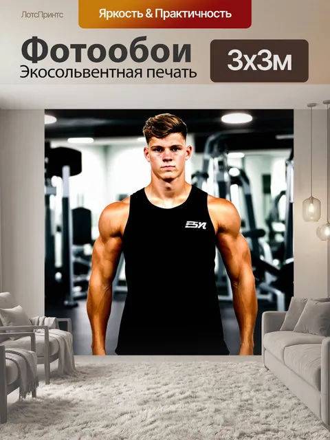 Фотообои Молодой атлет с мощным телосложением, одетый в черную майку без рукавов, стоит на фоне тренажерного зала