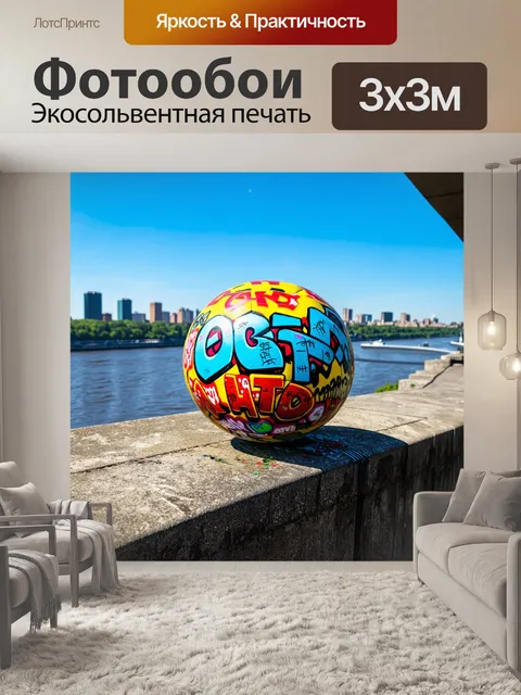 Фотообои мяч, украшенный граффити, стоит на старом бетоном мосту, с видом на реку и город на заднем плане