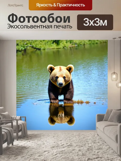 Фотообои медвежонок, исследующий берег озера, с отражением голубого неба и деревьев в воде, его глаза полны…